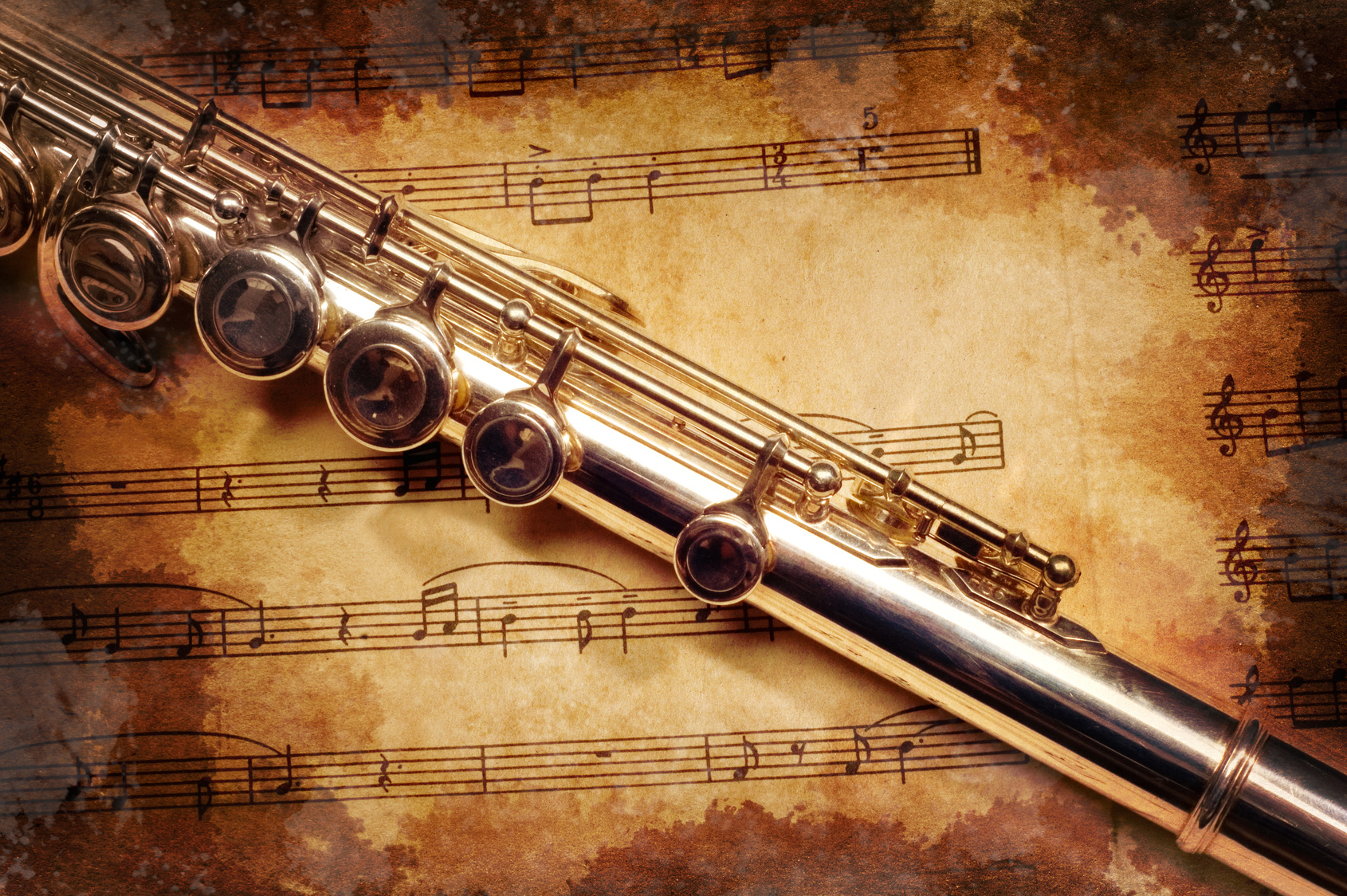 Silver flute on an ancient musical background -